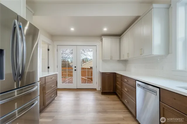 a large kitchen with stainless steel appliances granite countertop a refrigerator and a sink