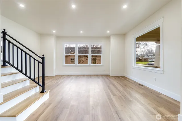 a view of an empty room with window and fire place