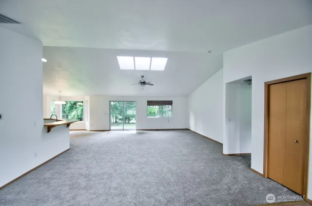 a view of a livingroom and a kitchen with furniture and a chandelier