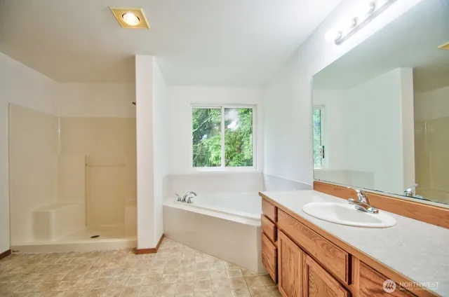 a bathroom with a granite countertop sink and a bathtub