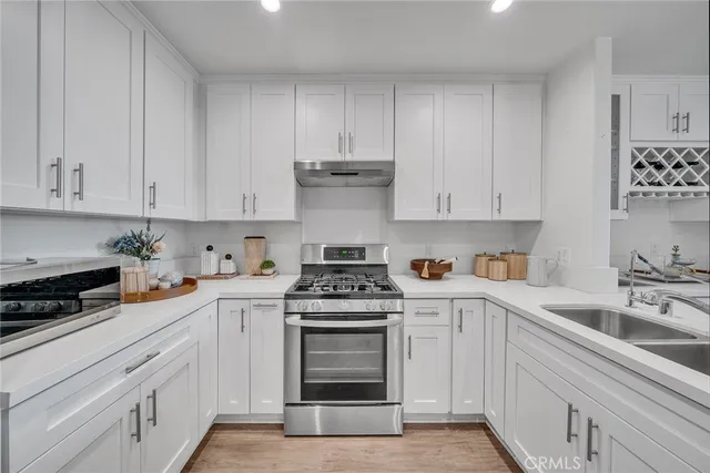 a kitchen with stainless steel appliances granite countertop a refrigerator and a stove top oven