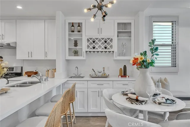 a kitchen with stainless steel appliances granite countertop a dining table and chairs