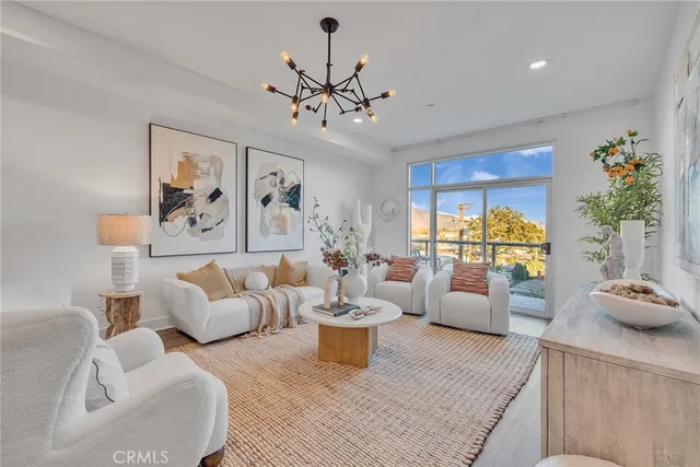 a living room with furniture and a chandelier