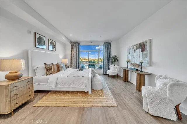 a view of a hallway with wooden floor and a bathroom