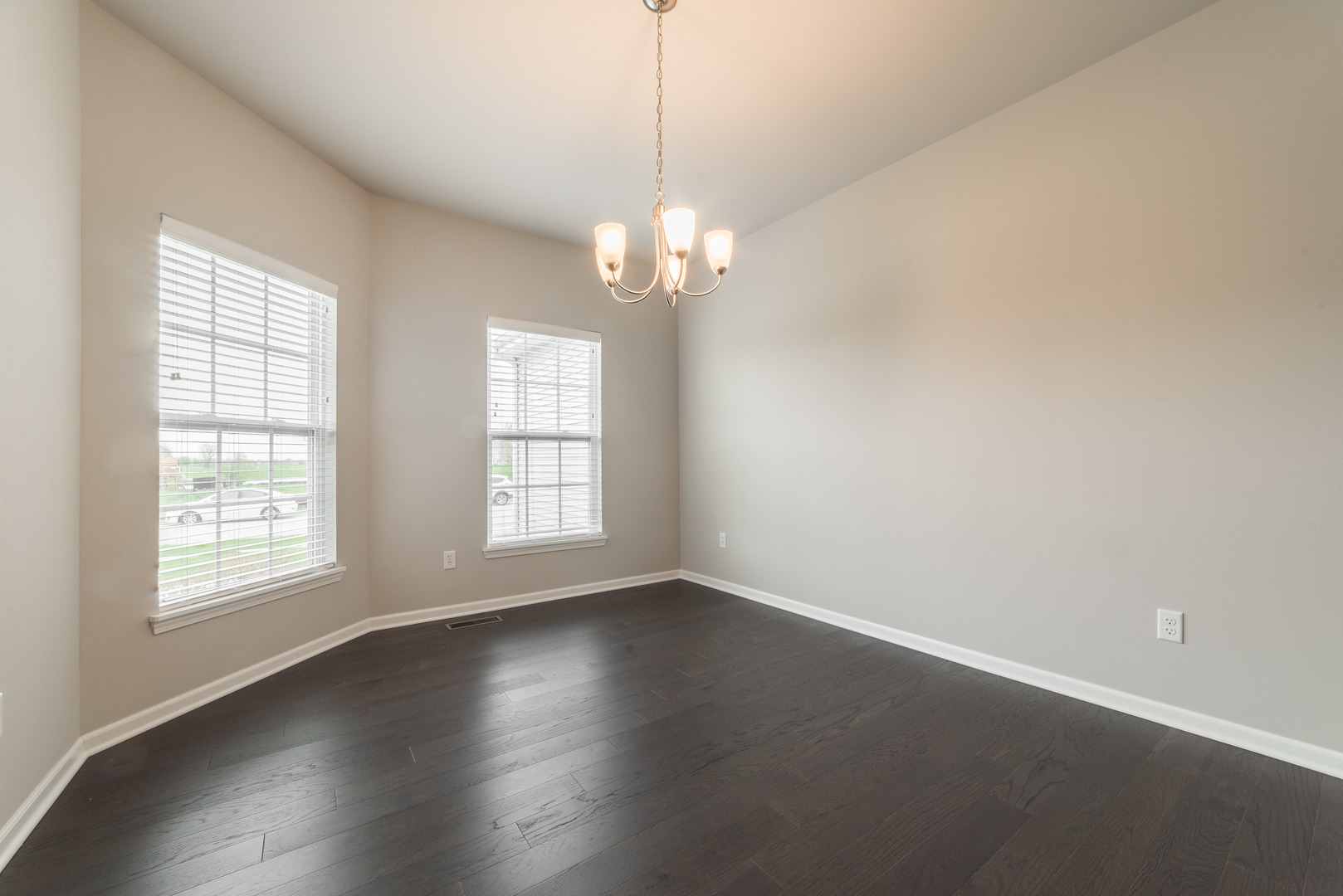 1111 Bailey Road Sycamore, IL 60178 - Photo 6 of 32 an empty room with wooden floor chandelier and windows