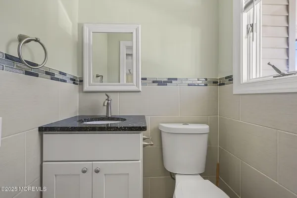 a bathroom with a granite countertop toilet sink and mirror