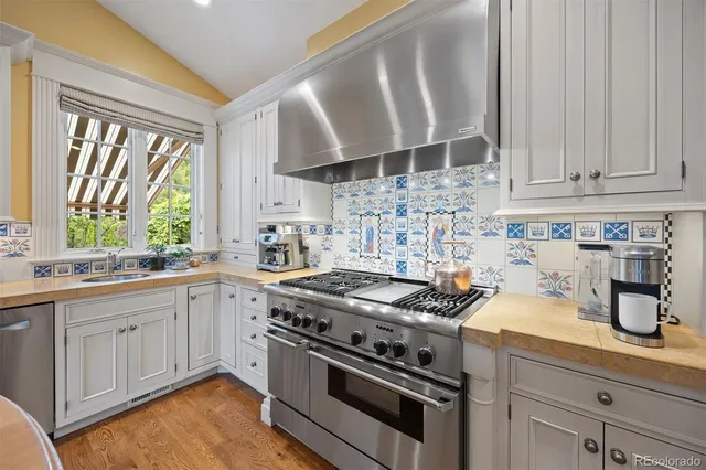 a kitchen with granite countertop a stove sink and cabinets