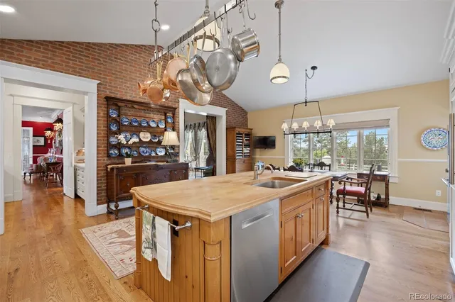a open kitchen with a table chairs and wooden floor