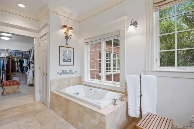 a bathroom with a tub a sink and a large mirror
