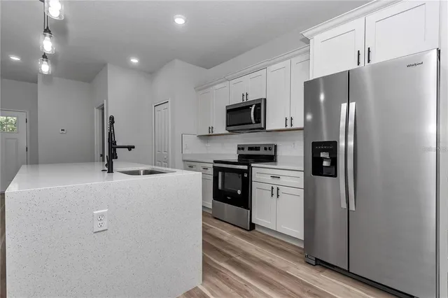 a kitchen with kitchen island a refrigerator stove and microwave