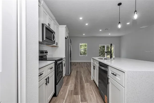 a kitchen with stainless steel appliances granite countertop a stove and a sink