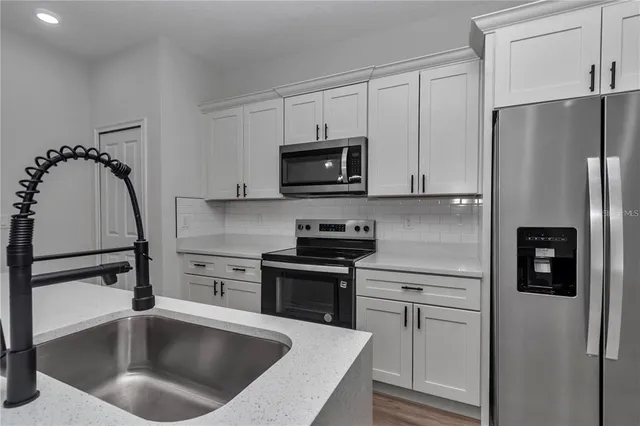 a kitchen with a refrigerator sink and microwave
