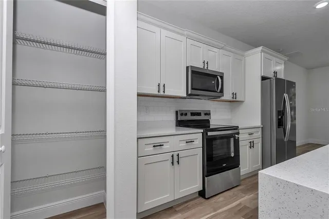 a kitchen with stainless steel appliances granite countertop white refrigerator stove a microwave oven a sink and dishwasher