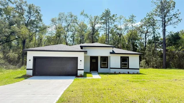 a front view of a house with yard and garage