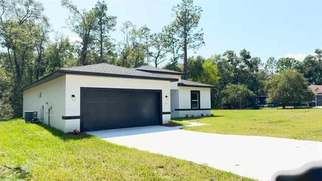 a view of a house with backyard and trees