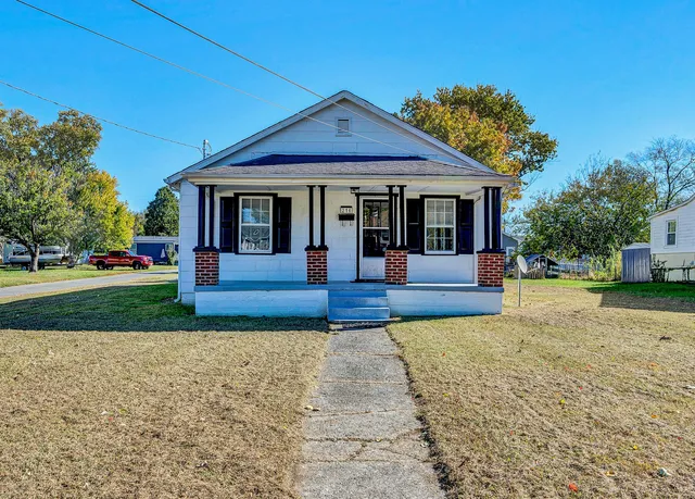 a view of a house with a small yard and potted plants