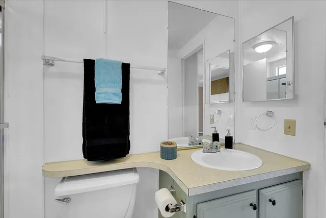 a bathroom with a granite countertop sink toilet and shower