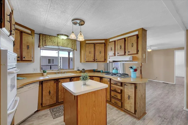 a view of a kitchen with wooden floor and a refrigerator