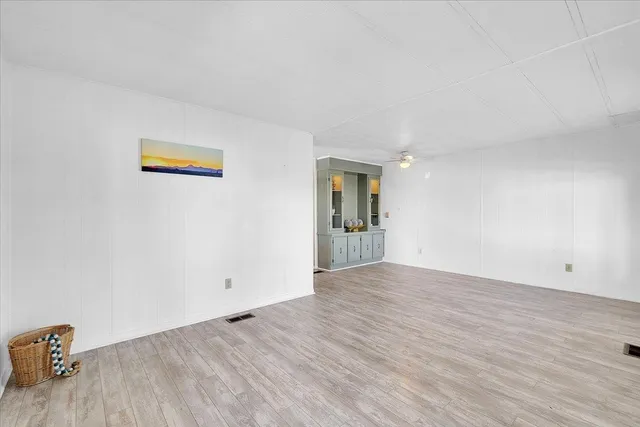 an empty room with window and wooden floor