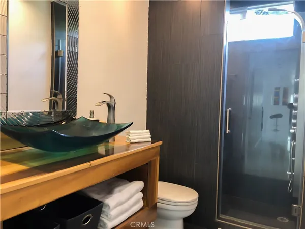 a bathroom with a sink a toilet and shower