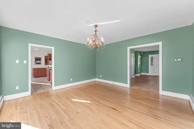 a view of empty room with wooden floor and fireplace