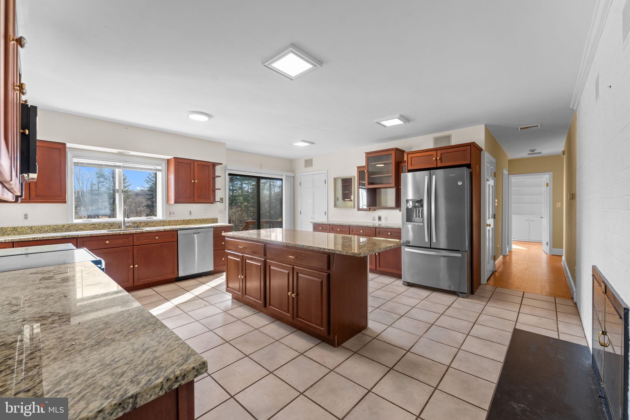 901 Walker Road Great Falls, VA 22066 - Photo 13 of 76 a large kitchen with kitchen island granite countertop a large counter top and stainless steel appliances