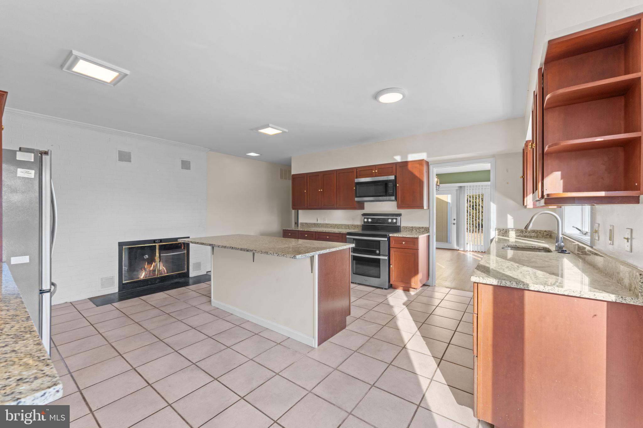 901 Walker Road Great Falls, VA 22066 - Photo 16 of 76 a kitchen with stainless steel appliances kitchen island granite countertop a sink and cabinets