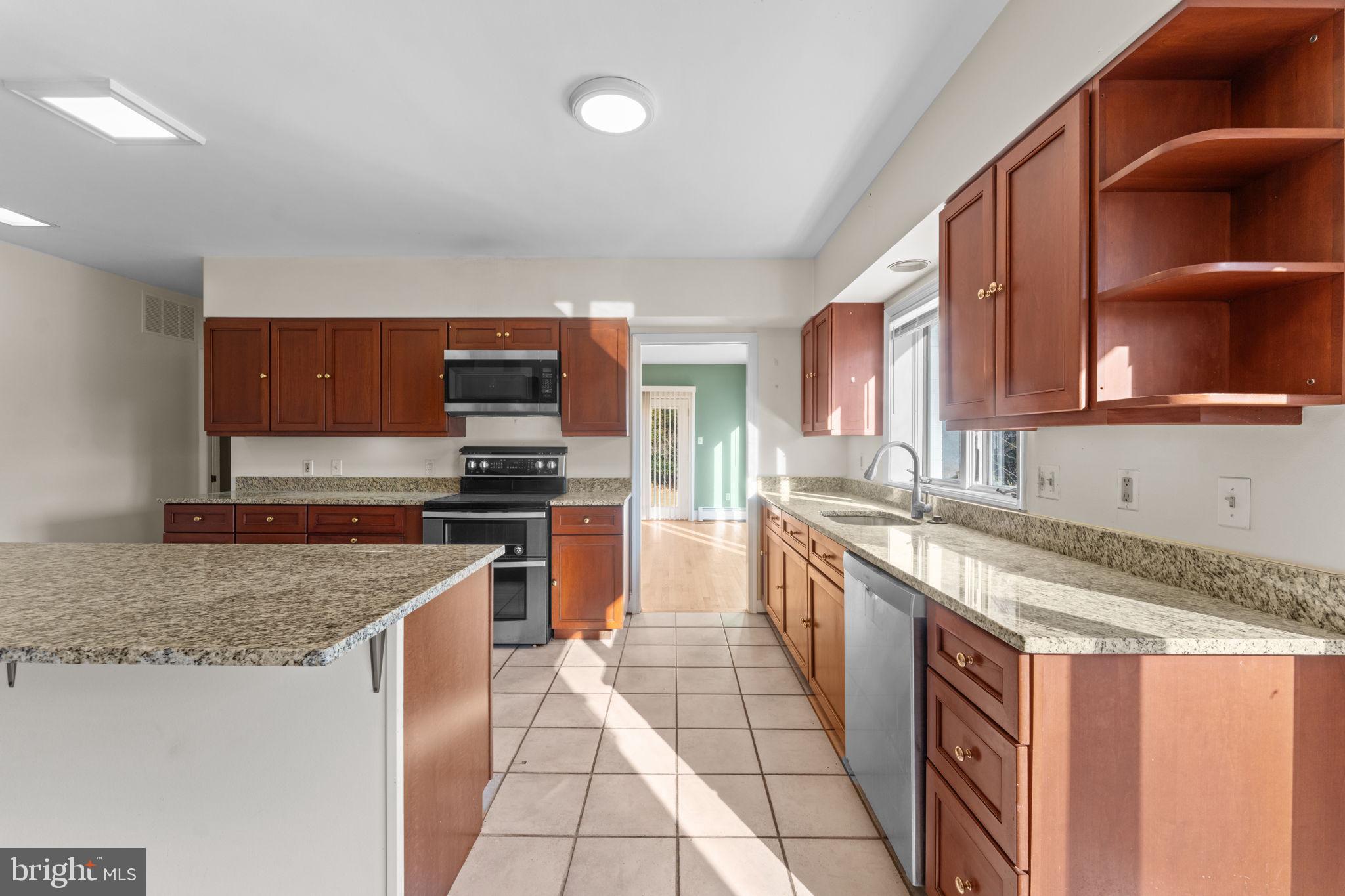 901 Walker Road Great Falls, VA 22066 - Photo 17 of 76 a kitchen with stainless steel appliances granite countertop a sink stove and microwave