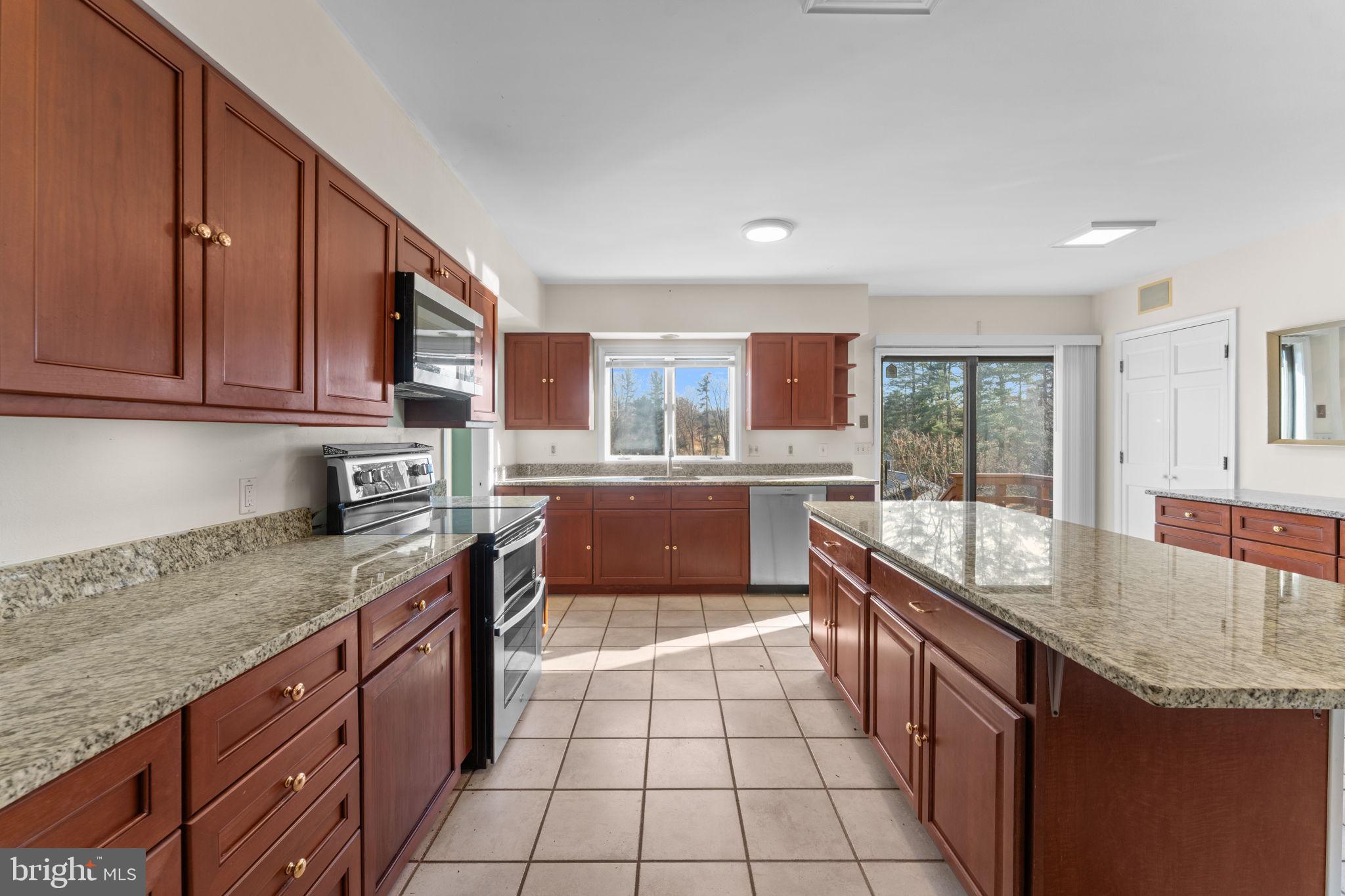 901 Walker Road Great Falls, VA 22066 - Photo 18 of 76 a large kitchen with granite countertop a stove sink and cabinets