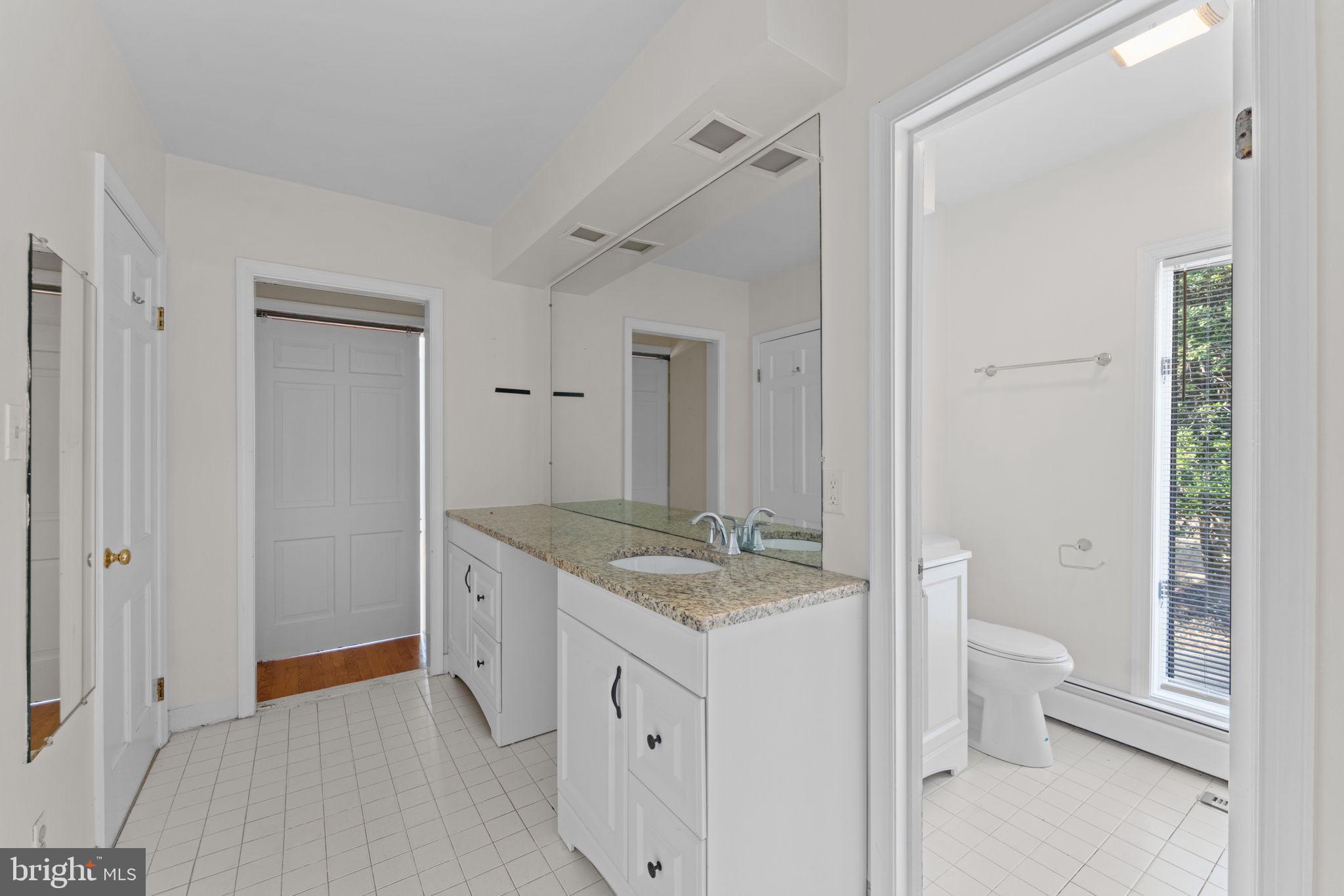 901 Walker Road Great Falls, VA 22066 - Photo 34 of 76 a bathroom with a granite countertop sink a toilet and shower
