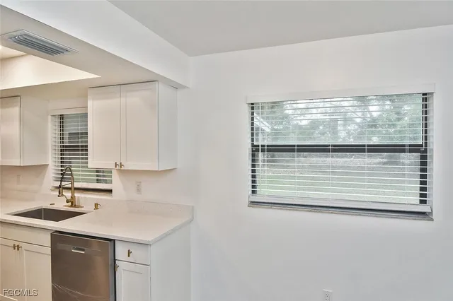 a kitchen with a sink cabinets and window
