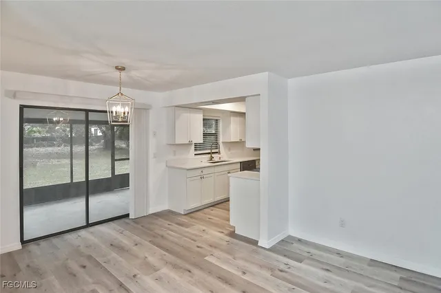 a view of a kitchen with wooden floor and a sink