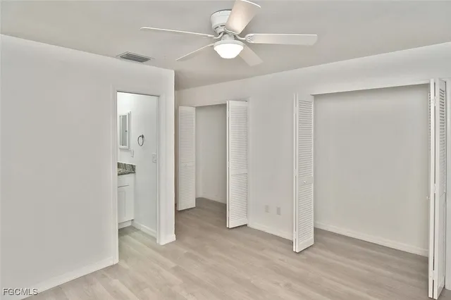 an empty room with closet and a ceiling fan