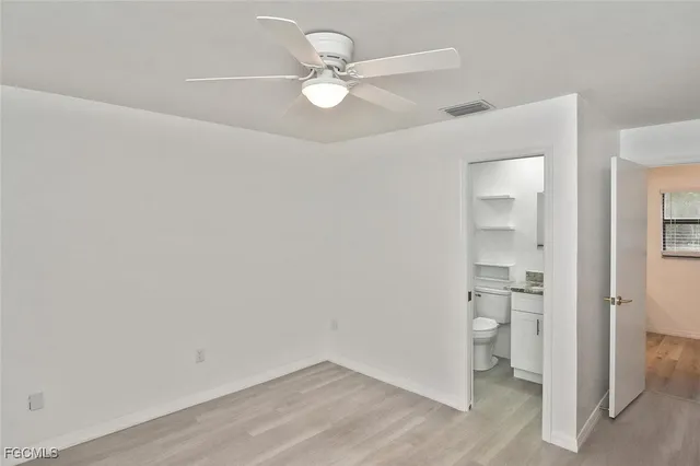 wooden floor in an empty room and a ceiling fan