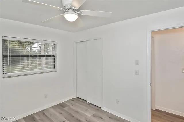 an empty room with a window and ceiling fan