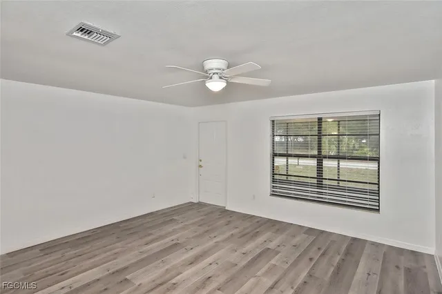 wooden floor in an empty room with a window
