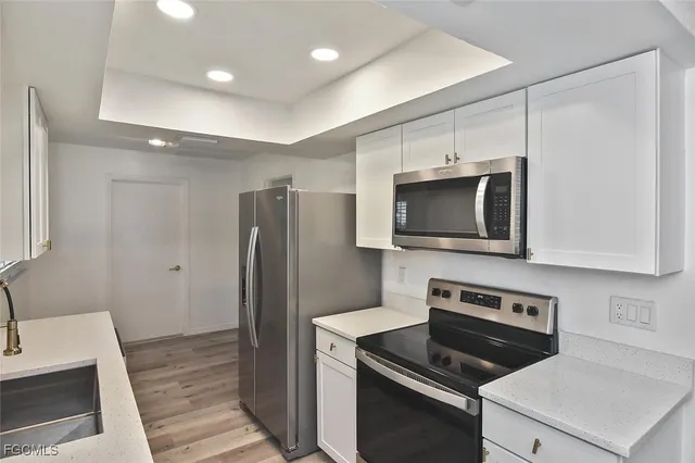 a kitchen with stainless steel appliances a stove a microwave and a sink