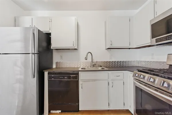 a kitchen with a sink a refrigerator and cabinets
