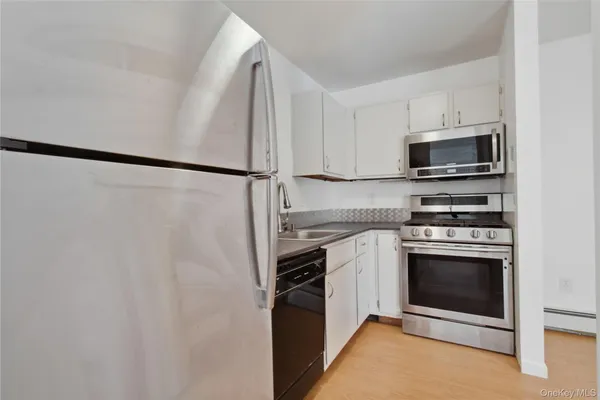 a kitchen with cabinets a stainless steel appliances and a refrigerator