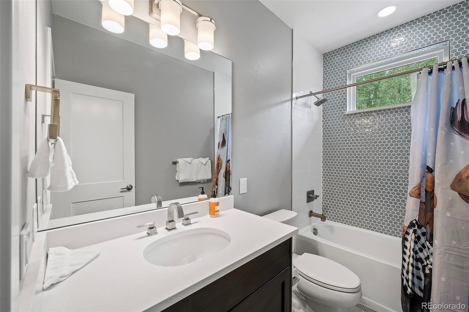 116 River Run Circle Fraser, CO 80442 - Photo 6 of 29 a bathroom with a sink a toilet a mirror a vanity and shower