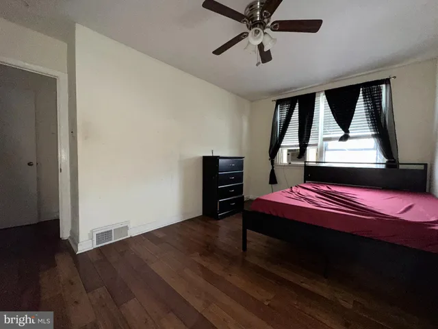 a bedroom with a bed a dresser and a window