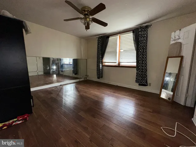 a view of a livingroom with hardwood floor and a ceiling fan