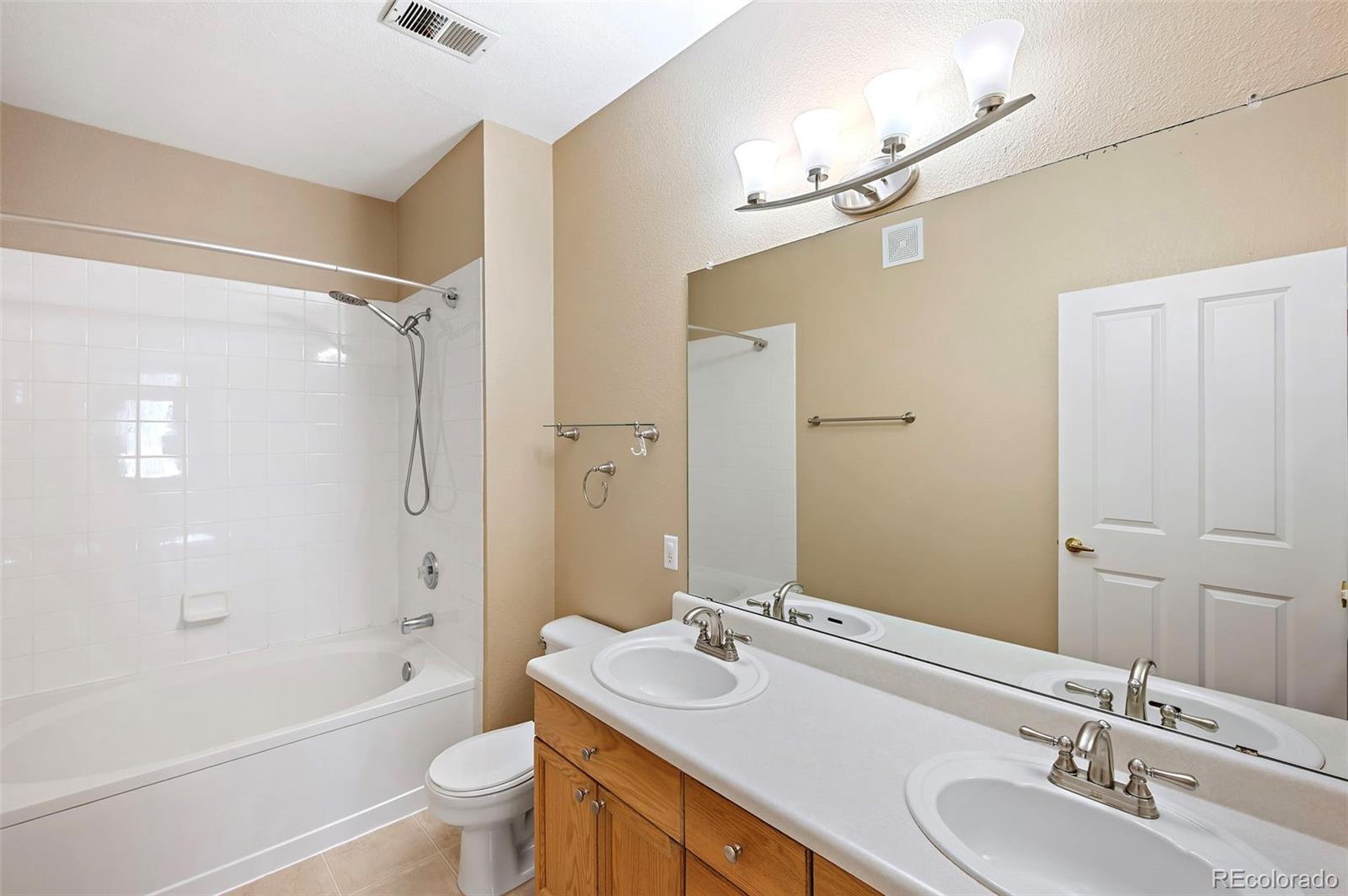 4064 South Carson Street, Unit 101 Aurora, CO 80014 - Photo 11 of 19 a bathroom with a sink a toilet and shower
