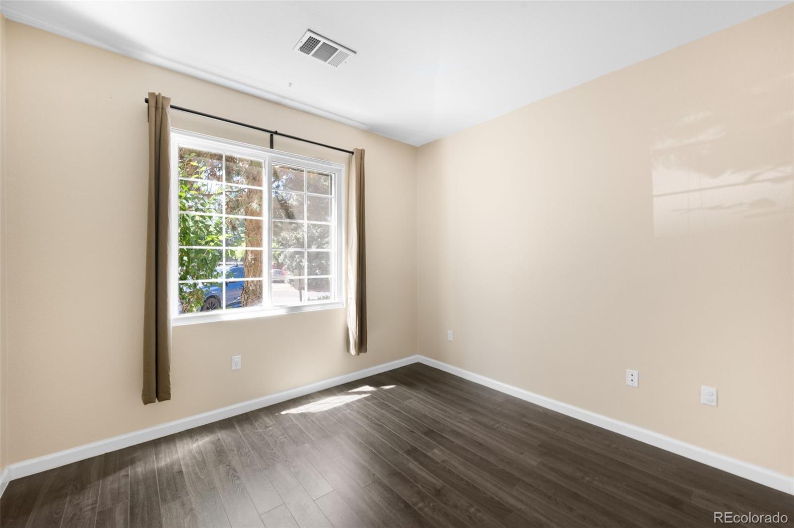 4064 South Carson Street, Unit 101 Aurora, CO 80014 - Photo 12 of 19 a view of an empty room with wooden floor and a window