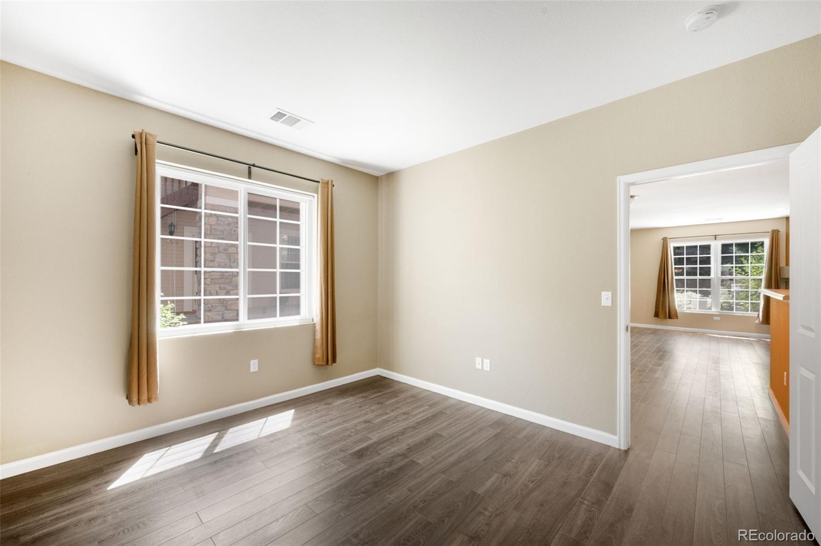 4064 South Carson Street, Unit 101 Aurora, CO 80014 - Photo 15 of 19 an empty room with wooden floor and windows