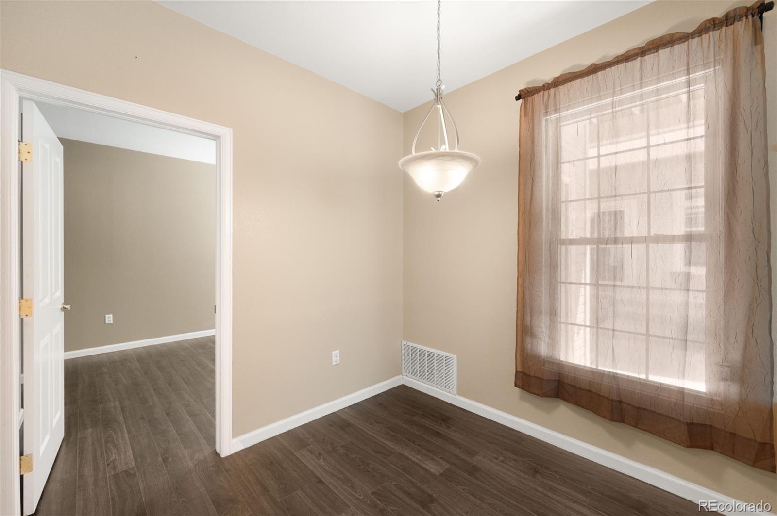 4064 South Carson Street, Unit 101 Aurora, CO 80014 - Photo 8 of 19 a view of an empty room with wooden floor and a window