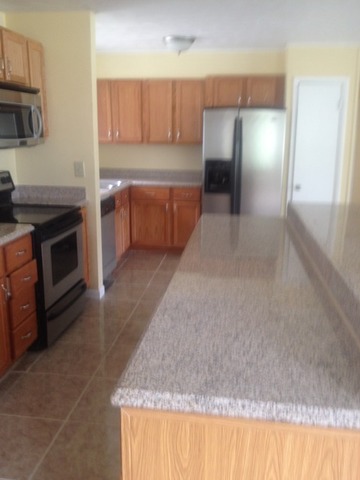 1000 North 3rd Street Rochelle, IL 61068 - Photo 9 of 14 a kitchen with kitchen island granite countertop a stove and a sink
