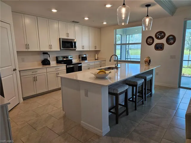 a kitchen with a table chairs microwave and cabinets