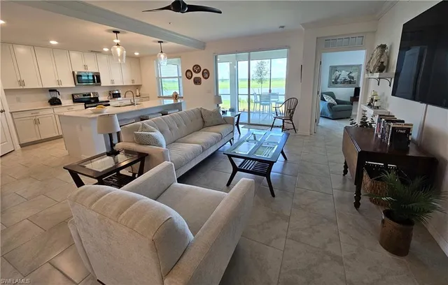 a living room with furniture a flat screen tv and a large window