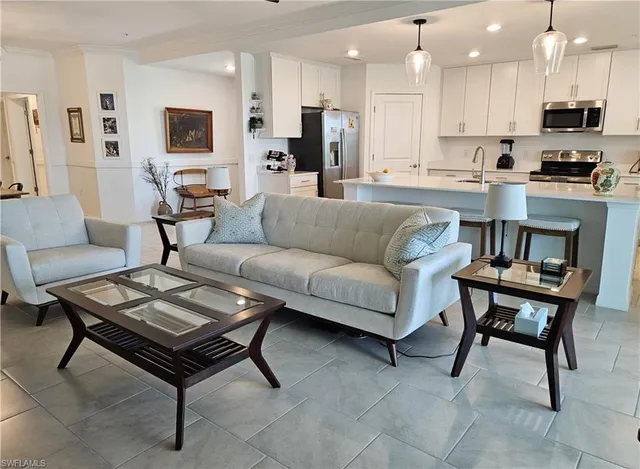 a living room with furniture a kitchen view and a a couch